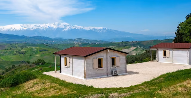 Gli edifici di Atessa Escapes sulla collina con le montagne sullo sfondo