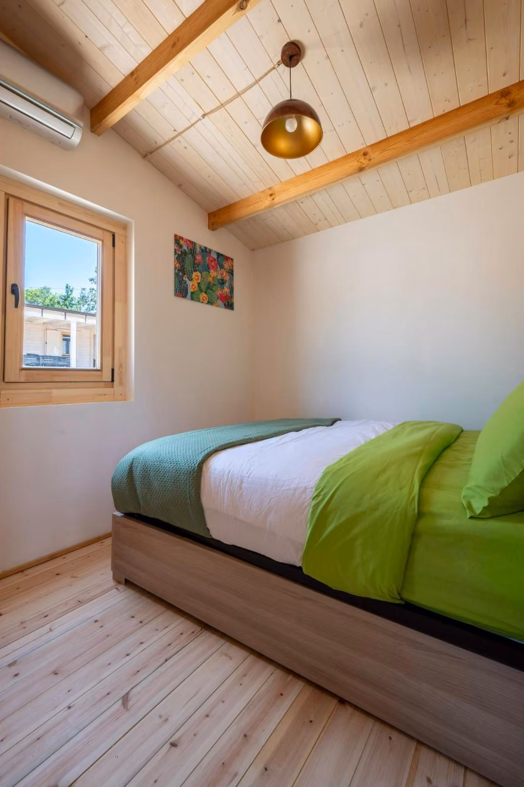 Camera da letto con letto matrimoniale e lenzuola verdi, finestra luminosa sulla campagna abruzzese